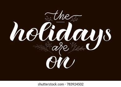 Hand drawn "The holidays are on" typography logotype as flyer, leaflet, booklet, brochure. White seasons greetings on black background. Concept promotion advertising with branches
