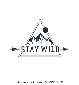 Hand drawn travel badge with mountain peaks textured vector illustration and "Stay wild" inspirational lettering.