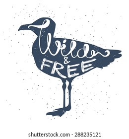 Hand drawn typography poster, greeting card or print invitation with seagull silhouette and phrase in it. 'Wild and free' hand lettering quote.