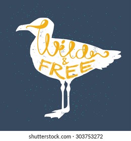 Hand drawn typography poster, greeting card or print invitation with seagull silhouette and phrase in it. 'Wild and free' hand lettering quote.