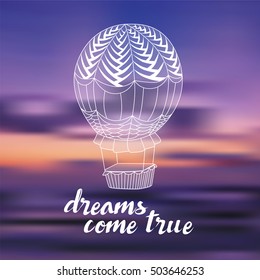 Hand drawn typography poster, greeting card or print invitation with balloon and phrase 'Dreams come true' hand lettering quote on blurred background.