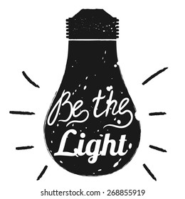 Hand drawn typography poster. Motivation quote Be the light  isolated on light bulb background. Calligraphy lettering vector illustration for home decoration.