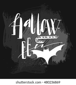 Hand drawn vector Halloween Poster with handwritten modern lettering word Halloween,bat and candy.Design element for halloween party or sign isolated on black chalkboard background.