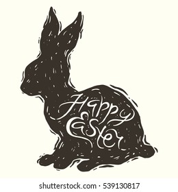 Hand drawn vector illustration of the easter rabbit silhouette in engraving style with handwriting inscription Happy Easter