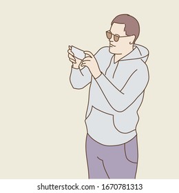 Hand drawn vector illustration of man in glasses using his smartphone. 