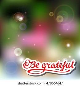 Hand drawn vector inspirational quote on blurred background with sparkles. Be grateful.