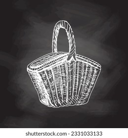 Hand drawn vector sketch of a wicker picnic basket. Doodle vintage illustration isolated on chalkboard background. Engraved immage. 