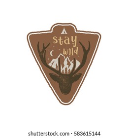 Hand drawn vintage camping badge and hiking label with wild animals design elements. Included deer head, mountains and quote text- "stay wild". Old style patch. Rustic stamp vector template..