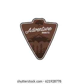 Hand drawn vintage camping badge and hiking label with mountains, forest, climb helmet and typography design elements. Quote text- Adventure awaits. Old style patch. Rustic stamp vector template.