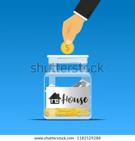 Hand dropping a coin into the house jar.