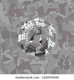 hand gripper icon inside grey camouflaged emblem
