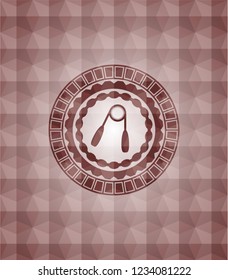 hand gripper icon inside red seamless emblem with geometric pattern background.