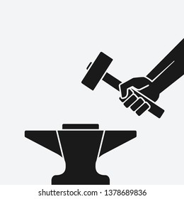 Hand with the hammer above anvil