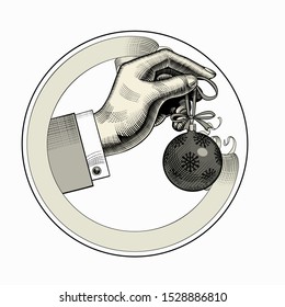 Hand hanging a Christmas tree ball on a spruce branch with a ribbon. Vintage engraving stylized drawing. Vector illustration
