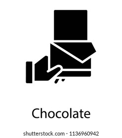 A hand held edible bar symbolizing chocolate 