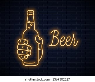 Hand hold beer bottle neon sign. Male hand holding a beer on wall background