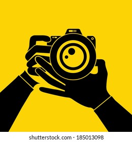 hand hold camera on yellow background