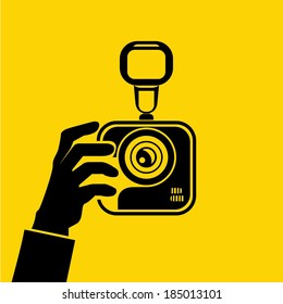 hand hold camera on yellow background