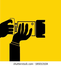 hand hold camera on yellow background