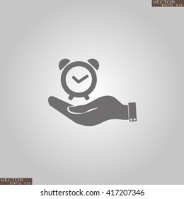 hand holding a alarm clock. Alarm icon . The clock shows the time
