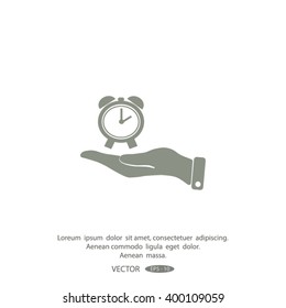 hand holding a alarm clock. The clock shows the time