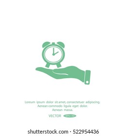hand holding a alarm clock. The clock shows the time