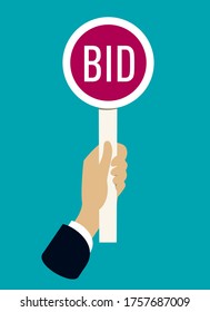 Hand holding auction paddle with bid