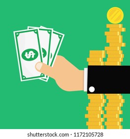Hand holding bills and background coins