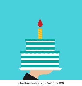Hand holding blue birthday cake