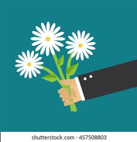 Hand holding a bouquet of daisies