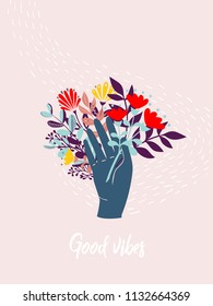 Hand holding bouquet of flowers with text Good Vibes