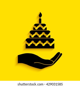 Hand holding a cake.