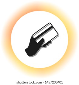 Hand holding a credit card. Dark icon with shadow on the glowing circle button. Illustration.