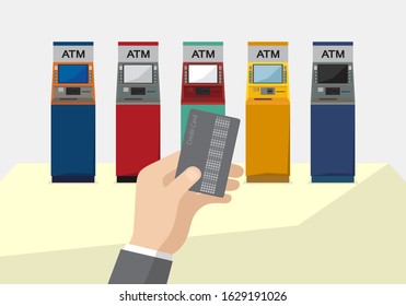 Hand holding credit card with different colored ATMs set background.