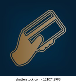 Hand holding a credit card. Vector. Golden icon and border at dark cyan background.