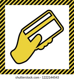 Hand holding a credit card. Vector. Warm yellow icon with black contour in frame named as under construction at white background. Isolated.