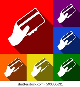 Hand holding a credit card. Vector. Set of icons with flat shadows at red, orange, yellow, green, blue and violet background.