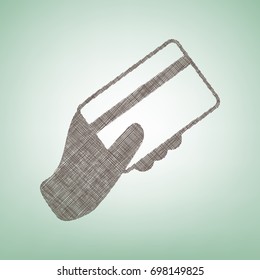 Hand holding a credit card. Vector. Brown flax icon on green background with light spot at the center.