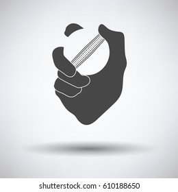 Hand holding cricket ball icon on gray background, round shadow. Vector illustration.