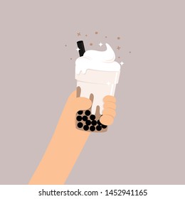 Hand holding a cup of milk tea.