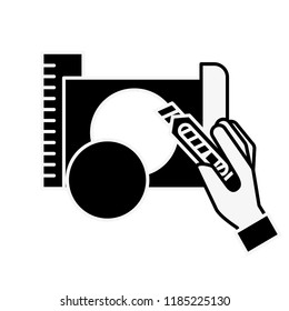hand holding cutter making circle with paper