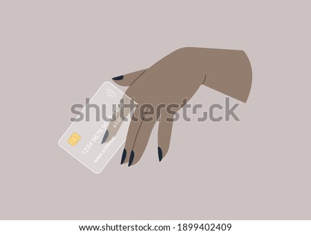 A hand holding a designer transparent plastic credit card, wireless transactions
