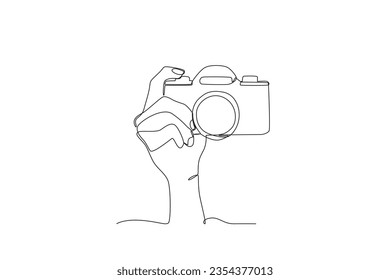 A hand holding a digital camera. World photography day one-line drawing