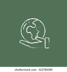 Hand holding the Earth hand drawn in chalk on a blackboard vector white icon isolated on a green background.