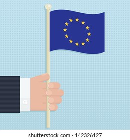 hand holding european union flag on blue background