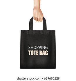 Hand holding fashionable black canvas shopping tote bag with lettering realistic close up view vector illustration  