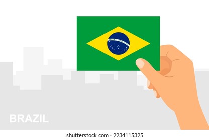 Hand holding the flag of Brazil on the background of the city in minimal flat style. Vector illustration