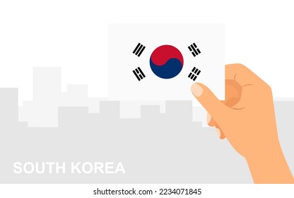 Hand holding the flag of South Korea on the background of the city in minimal flat style. Vector illustration