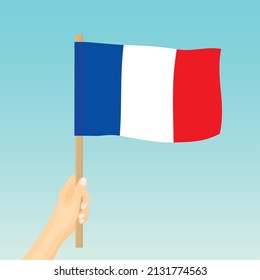 hand holding France flag against blue sky- vector illustration