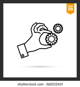 Hand holding gear wheels